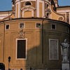 Statue of St. Charles Borromeo with the apse of the Church of San Carlo al Corso in the background