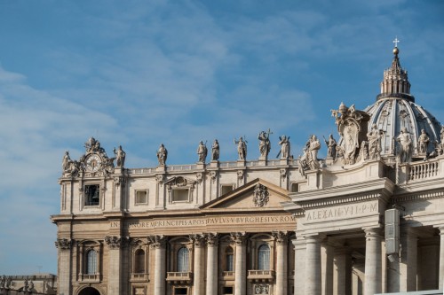 Fragment of the facade of the Basilica of San Pietro in Vaticano and the colonnade with the coat of arms of Pope Alexander VII