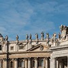 Fragment of the facade of the Basilica of San Pietro in Vaticano and the colonnade with the coat of arms of Pope Alexander VII